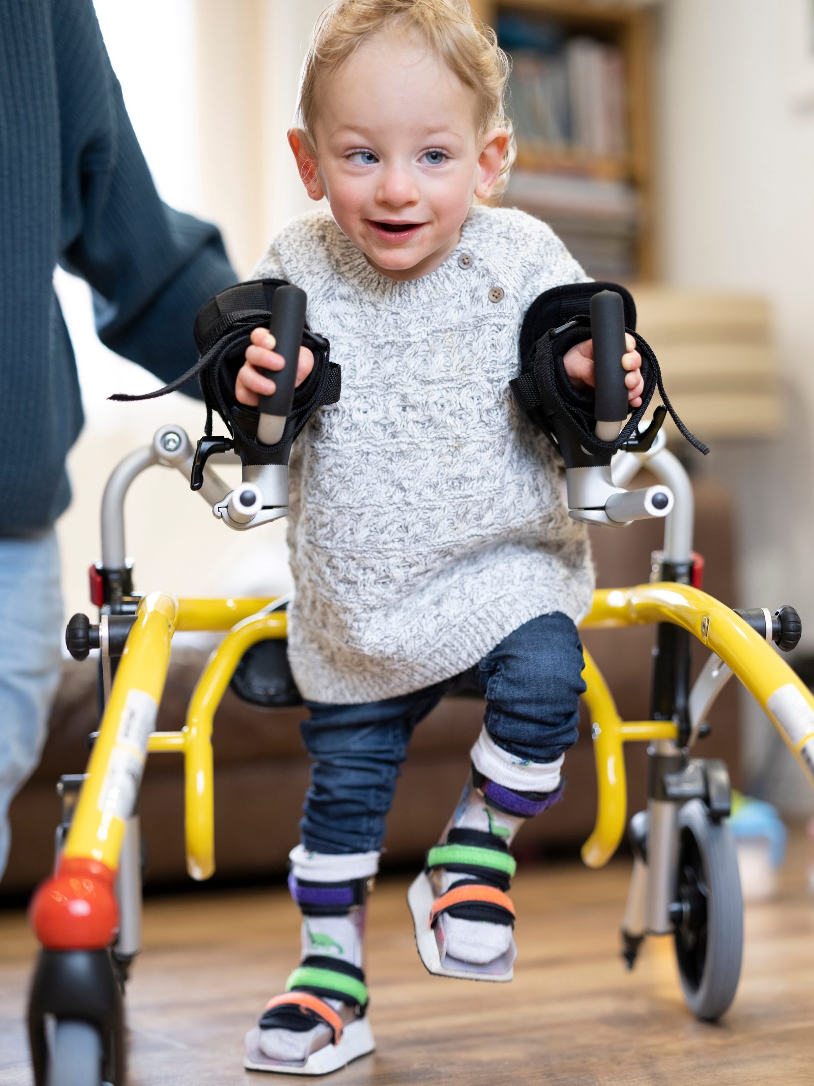 Child with yellow walking frame - rehabilitation starts at any age
